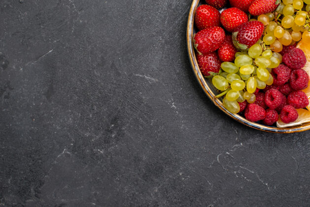 成分顶视图水果成分草莓葡萄覆盆子和橘子托盘内的深灰色空间葡萄可食用水果托盘