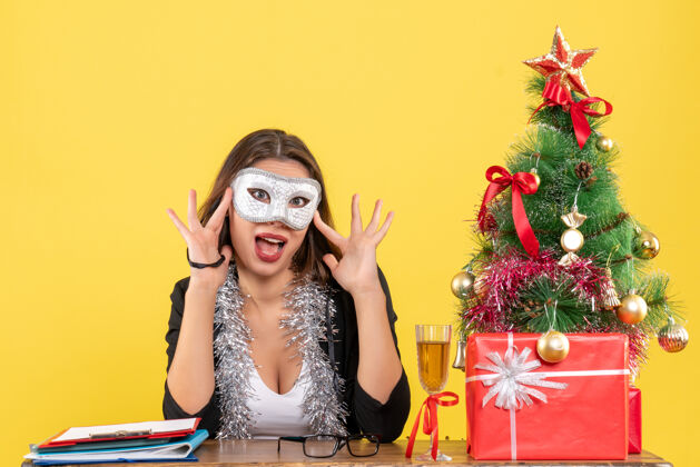 快乐新年心情带着幸福的笑容迷人的女士穿着西装戴着口罩在黄色隔离的办公室里成人心情感性