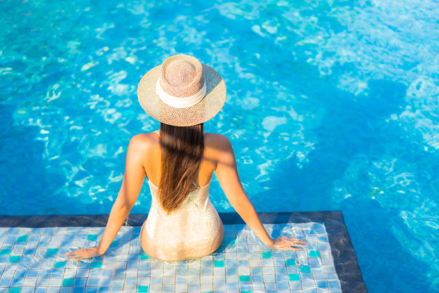 亚洲美丽的年轻女子在游泳池放松的画像阳光酒店年轻