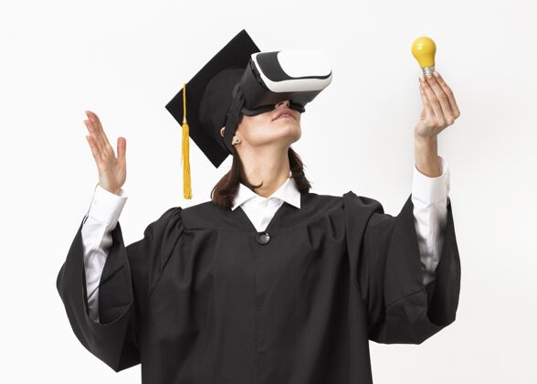 毕业帽穿着毕业礼服戴毕业帽戴着虚拟现实耳机的女人仿真毕业技术