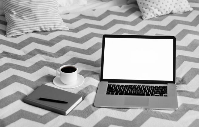 咖啡杯议程和笔记本电脑旁边的移动技术卧室笔记本电脑