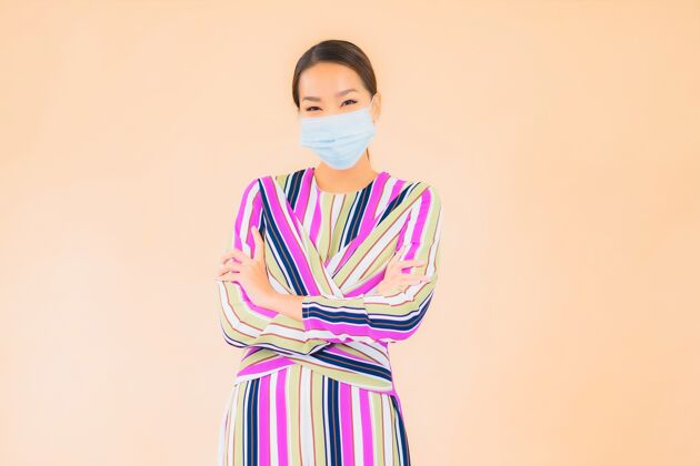 亚洲人肖像美丽的亚洲年轻女子戴上口罩以防晕病毒或covid19上色护理空气流感