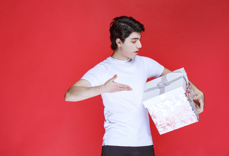 模特一个男人拿着一个五颜六色的礼盒指着什么地方年轻年轻人男性