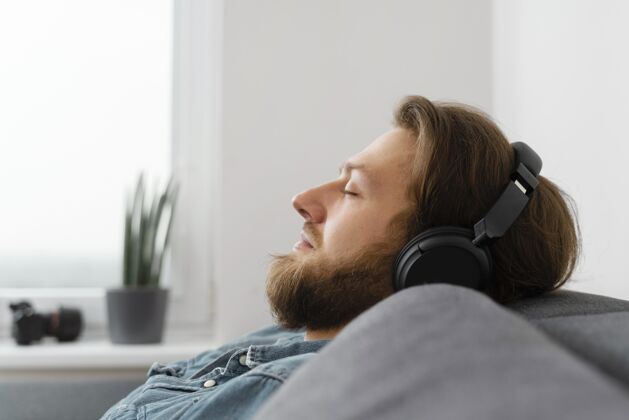 男人用耳机睡觉的男人睡眠室内男性