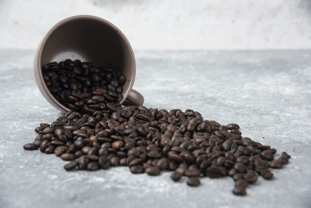 烤香喷喷的烤咖啡豆从大理石表面的杯子里出来农作物香味