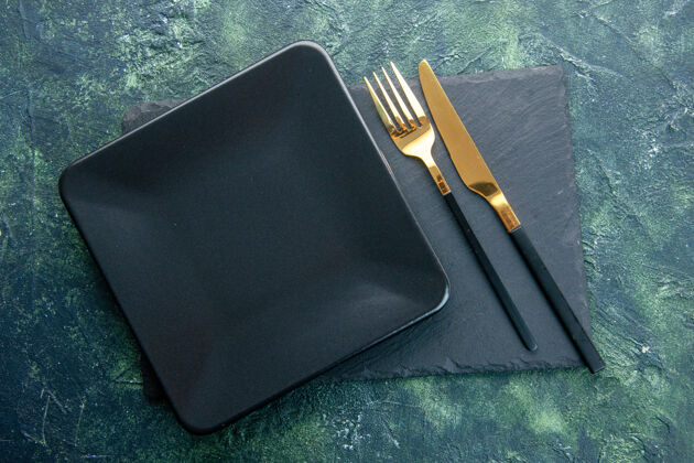 餐厅俯视图黑色方形板与金色刀叉上的深色背景色餐厅餐具晚餐厨房厨房笔记本晚餐