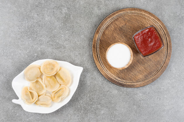 木头一盘饺子和酱汁放在大理石表面糕点正餐菜肴