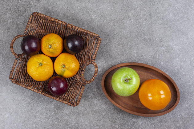 健康柳条篮子上放着新鲜的甜橘子和李子食物水果美味