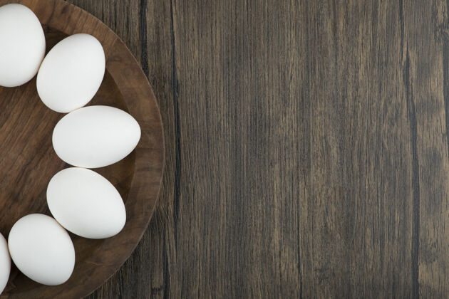 有机在木头表面放上生的有机鸡蛋的木板天然烹饪鸡蛋