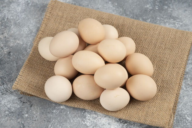 贝壳一堆有机生鸡蛋和桌布放在大理石表面鸡桌布烹饪
