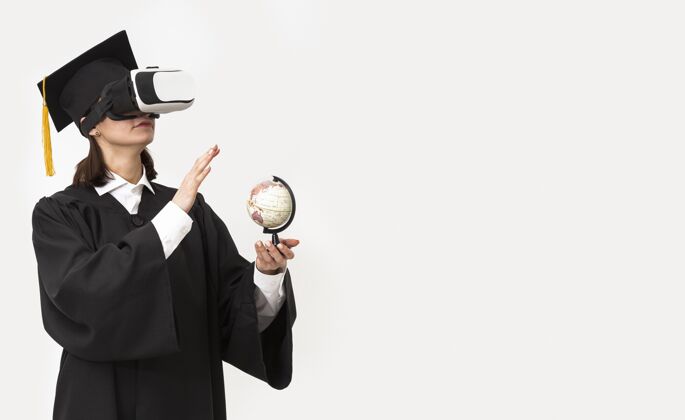 虚拟现实模拟器穿着毕业礼服戴毕业帽戴着虚拟现实耳机的女人女人技术虚拟现实耳机