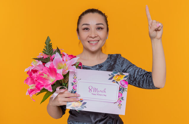 手指快乐积极向上的亚洲女性母亲手持花束和贺卡庆祝国际妇女节三月表演积极站立