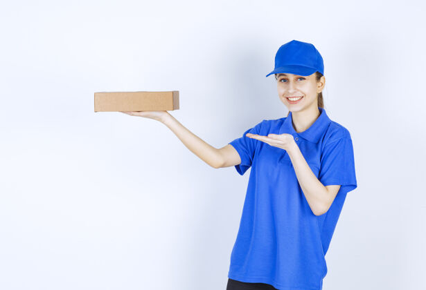 送货穿着蓝色制服的女孩手里拿着一个纸板外卖盒促销服装聪明