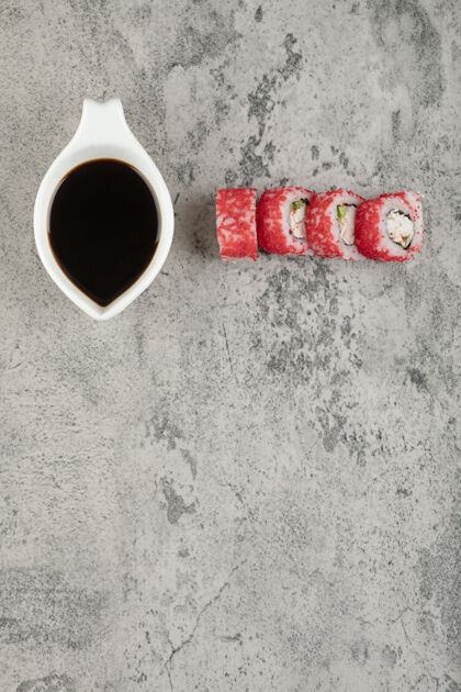 面包卷传统的酱油和寿司卷 石头表面有鱼子酱碗传统美味