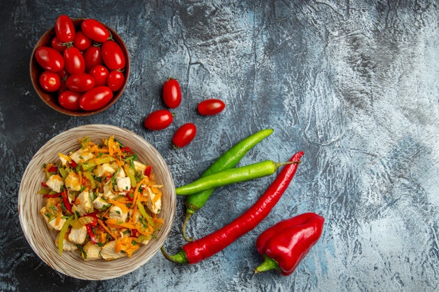 膳食鸡肉沙拉的顶视图和红色西红柿在光的表面胡椒辣椒食物