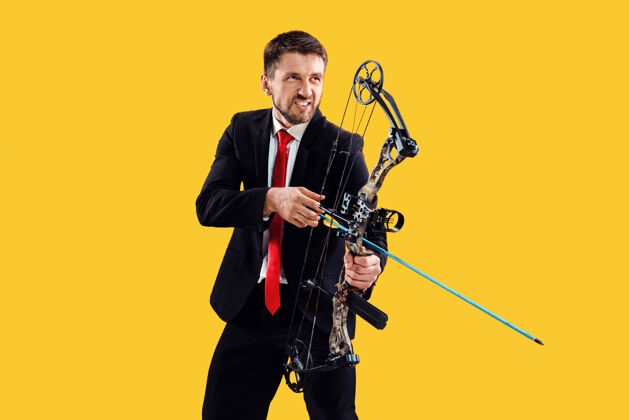 射击商人用弓箭瞄准目标 孤立在黄色工作室背景上商业 目标 挑战 竞争 成就理念活动人专注