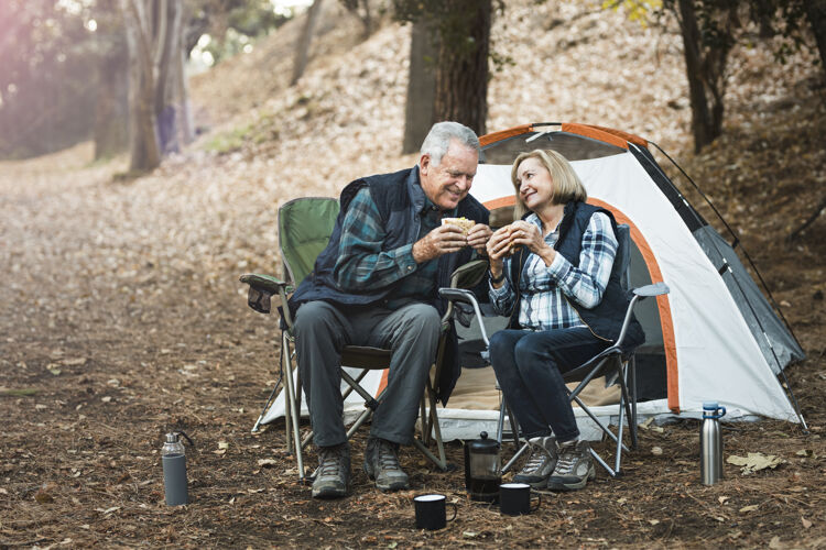 祖父母浪漫的老年夫妇在营地野餐人老年面包