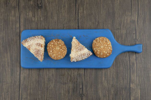 糕点蓝色的全麦饼干和甜饼切板放在木桌上食品小吃燕麦