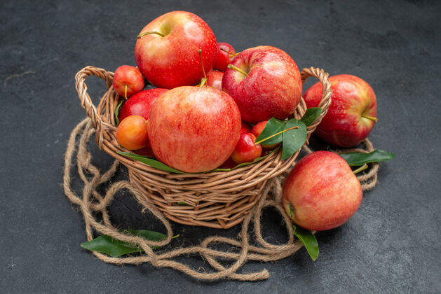 木头侧面特写查看水果木篮里的开胃樱桃和苹果叶成熟篮子壁板