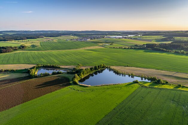 农场在一个乡村地区 鸟瞰着美丽的绿色田野和小池塘食物天风景