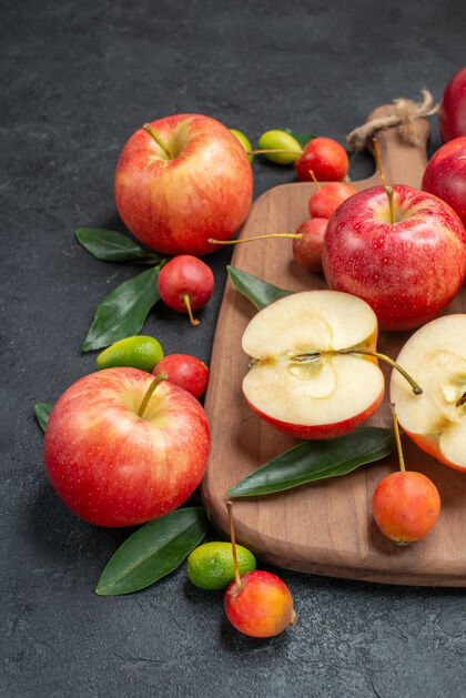 特写侧面特写查看水果与水果旁边的董事会上的叶子浆果苹果板多汁