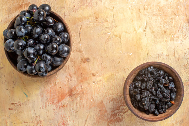 葡萄顶部特写查看葡萄碗黑葡萄和葡萄干在桌上黑莓餐桌健康