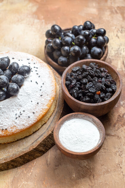 有机一块蛋糕一块蛋糕在木板上一碗碗葡萄糖葡萄干蓝莓浆果板
