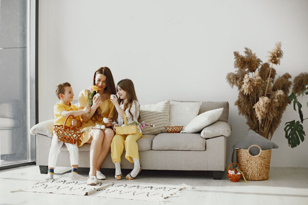 鸡蛋妈妈带着女儿和儿子在家编一个节日篮子穿节日的衣服篮子女孩油漆
