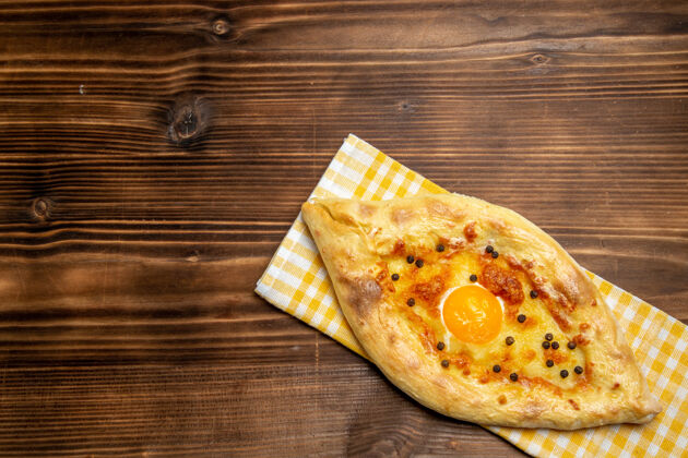 切片俯视图美味的鸡蛋面包从烤箱里拿出来放在棕色桌子上的面团面包包早餐生的小吃早餐