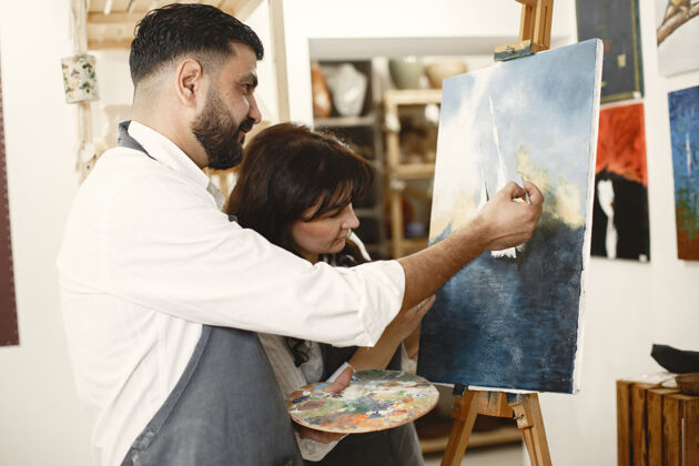 夫妇一对成年夫妇在艺术工作室里的爱情故事他们画画 大笑 亲吻他们的情感 感情 爱阿拉伯语班级成人