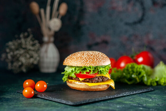 快餐前视图美味的肉汉堡包与红色西红柿在黑暗的背景红色汉堡包奶酪