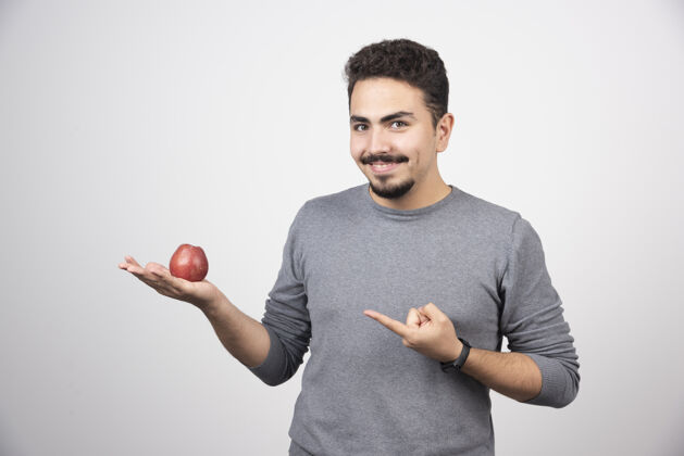 模型黑发男人指着灰色的红苹果苹果男孩自然