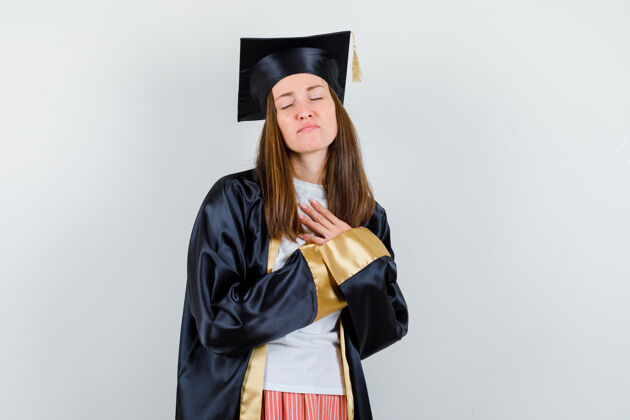 毕业毕业的女人手放在胸前 穿着休闲服 制服 看上去充满希望正面图女性大学大学