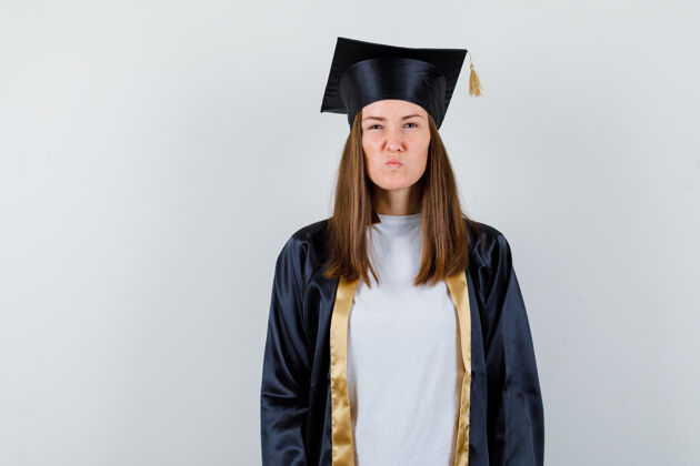 教育女毕业生一边看着相机 一边皱着眉头 穿着制服 看上去很倔强前视图人成就多样性
