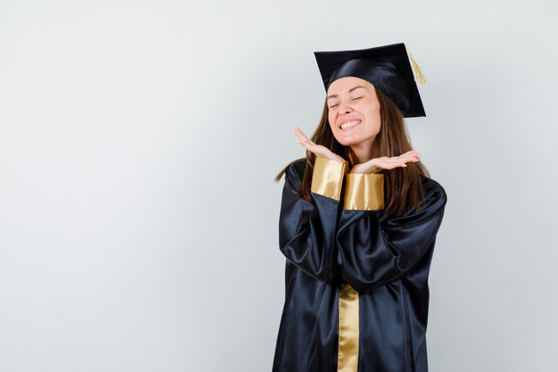 成功女毕业生身着学院服 双手放在下巴下 看着幸福的前景色Cap保持肖像
