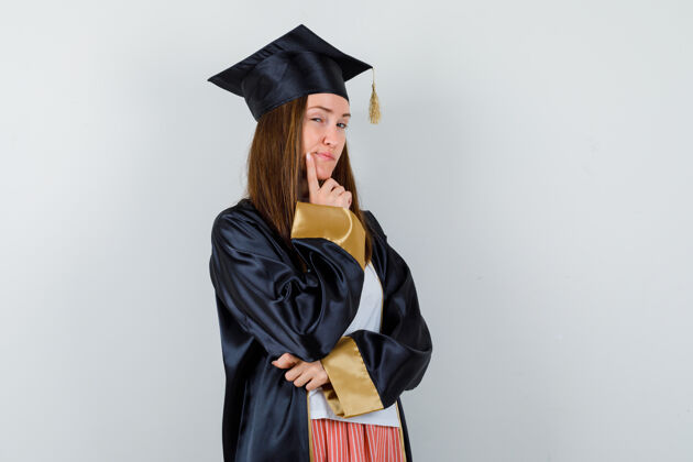 肖像女毕业生穿着校服站在思考的姿势 穿着休闲服 看起来很懂事 前视成功毕业典礼Campus