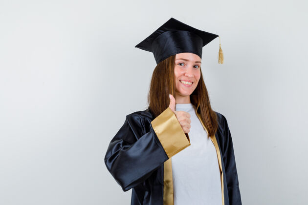 秀女学生穿着毕业礼服竖起大拇指 看上去很高兴正面图Campus女性证书