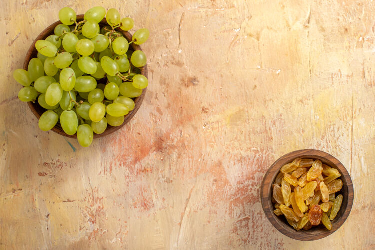 葡萄顶部特写查看葡萄桌上的葡萄干和绿色葡萄碗葡萄酒桌子葡萄干