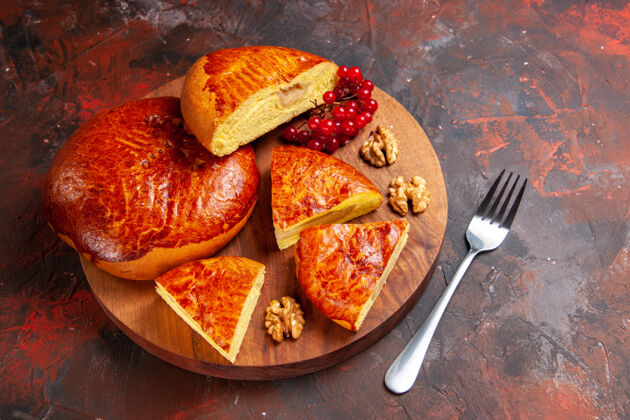 料理前视图美味的馅饼切片与红色浆果在黑暗的办公桌糕点馅饼蛋糕甜胡椒粉餐厅肉