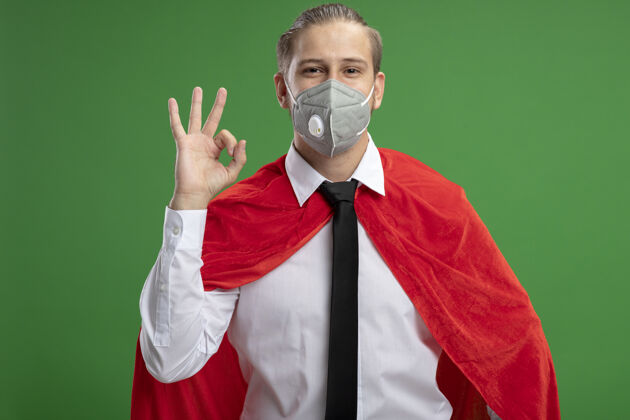 面具年轻的超级英雄戴着医用面具打着领带 在绿色背景上显示出良好的姿态医疗表演请