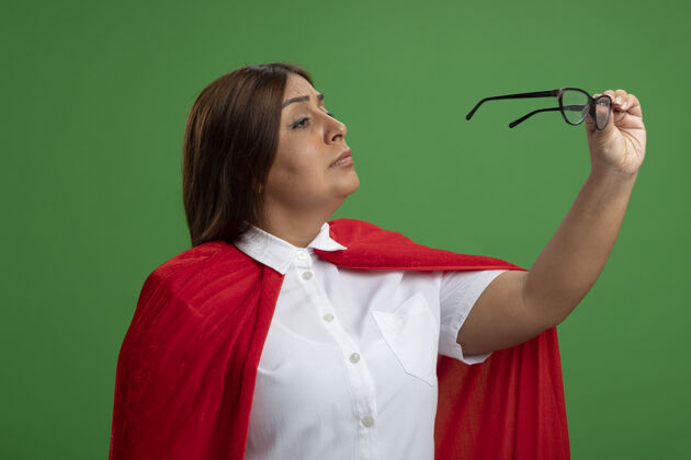 女性中年女超人抱着眼镜看着绿色的背景持有思考超级英雄