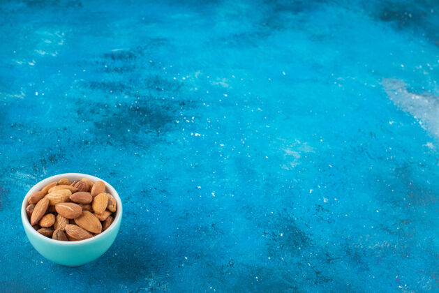 蛋白质在蓝色表面的碗里放着没有壳的杏仁杏仁碗美味