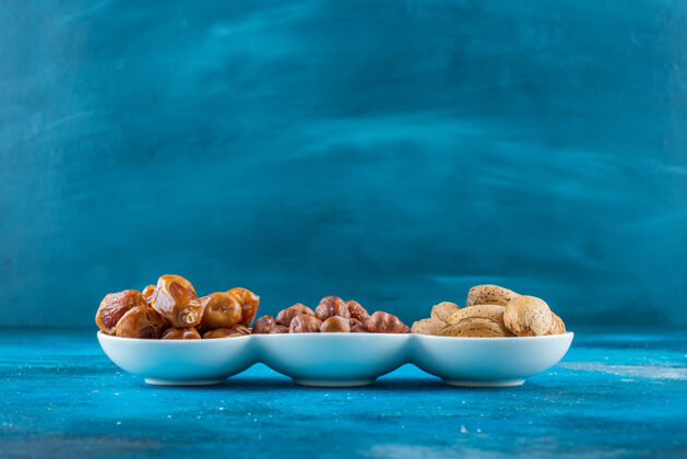 蛋白质在蓝色表面的碗里混合着坚果榛子美味自然