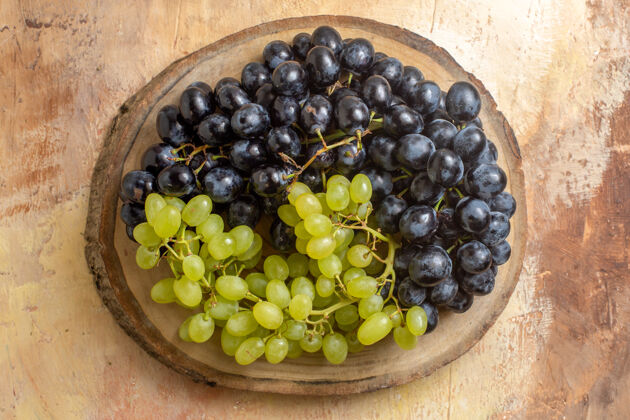 藤蔓顶部特写镜头葡萄串绿色和黑色的葡萄在砧板上葡萄健康葡萄酒