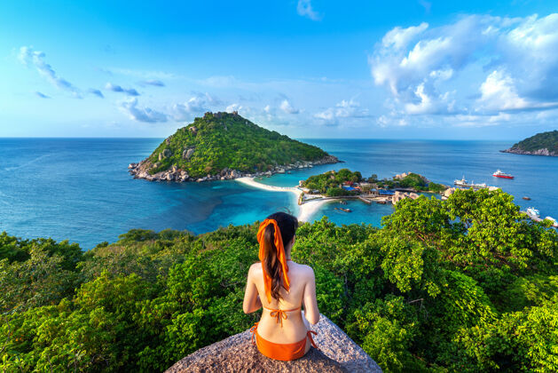 肖像穿比基尼的女人坐在泰国的楠园岛上美丽度假海