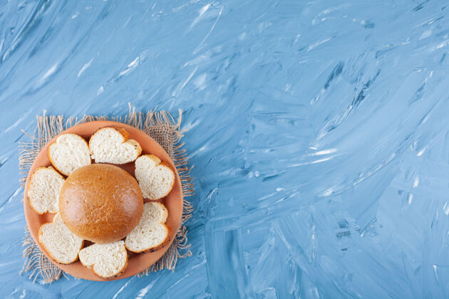 顶视图蓝色表面上的白色烤面包片陶瓷盘子烘焙食物小吃