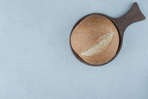面包木板上的黑麦面包卷健康棕色面包卷