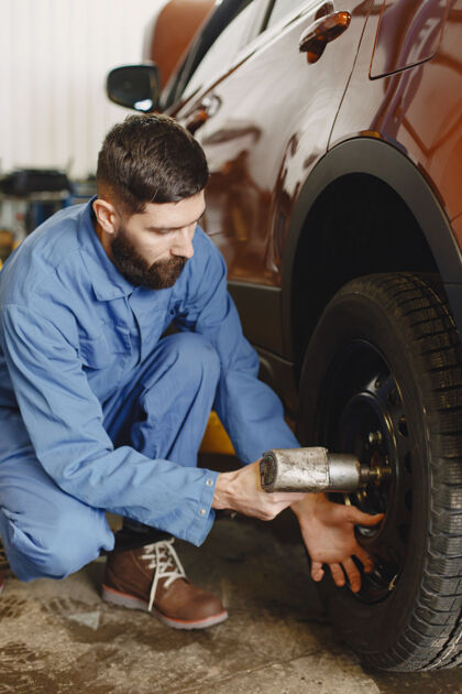 修理工机械师拿着工具机械师手里拿着轮子蓝色工作服修理服务汽车