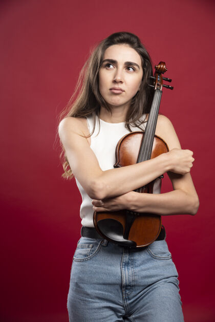 女人拥抱小提琴的年轻女模特乐器站立模特