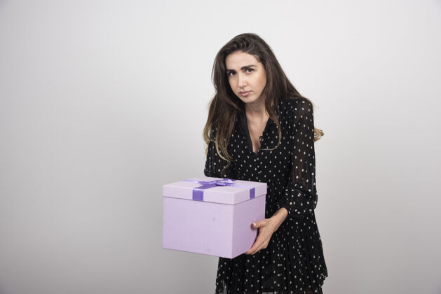 礼物年轻女子拿着一个紫色的礼盒持有情感女性